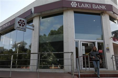 A woman walks out of a branch of Laiki Bank in Nicosia